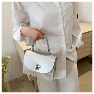 Detail of silver faux leather and beige straw woven crossbody bag with metal lock