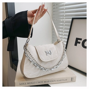 Détail du sac crème à motif marbré avec fermoir papillon argenté et chaîne décorative