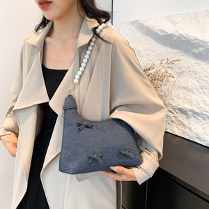 Denim underarm bag with decorative bows and elegant large pearl shoulder strap