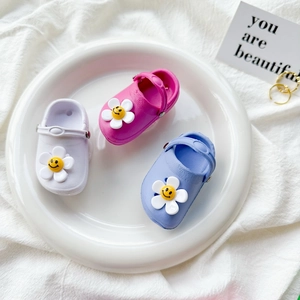 Mini floral clog shoe phone grips in white, pink, and blue colors on a decorative tray