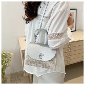 Detail of silver metallic flap and woven texture on a minimalist small square handbag