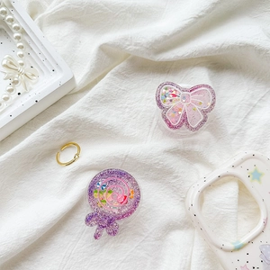 Detail of purple glitter butterfly and lollipop phone grip with sparkling sequins