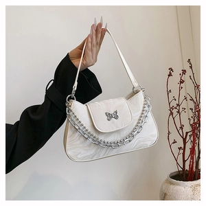 Détail du sac à bandoulière blanc à motif marbré avec boucle papillon argentée et chaînes