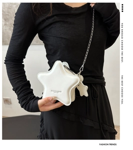 Close-up of white star-shaped crossbody bag with silver chain strap and leather texture