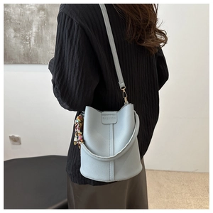 Detail der hellblauen Beuteltasche mit Litschi-Lederstruktur und modischer Prägung