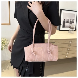 Sac à bandoulière rose motif marbre avec bandoulière nouée porté par un mannequin
