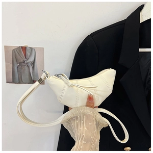 Detail of creamy white crescent shoulder bag with vertical stitching and silver zipper