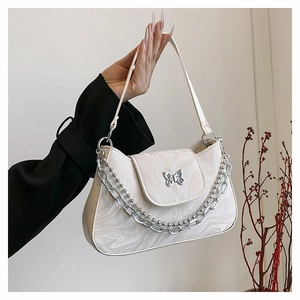 Détail du sac à bandoulière blanc marbré avec boucle papillon argentée et bandoulière chaîne