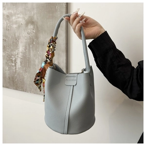 Detail der hellblauen Beuteltasche aus Litschileder mit Fashion-Prägung und Seidenschal