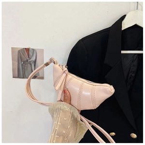 Detail of pink croissant-shaped crossbody bag with vertical pleated stitching details