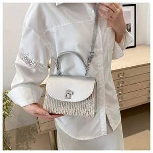 Detail of silver metallic flap and woven texture on a stylish square handbag
