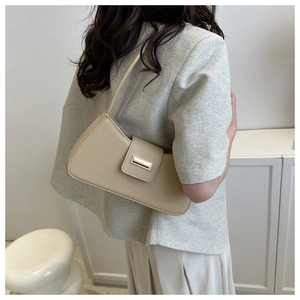Detail einer schicken beigen Leder-Baguette-Tasche mit eleganter goldener Metallschnalle
