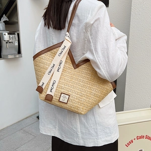 Fashionable large straw tote bag with brown leather trim and chic shoulder straps