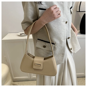 Detaillierte Nahaufnahme einer beigen Baguette-Tasche mit glatter Textur und Metallschnalle