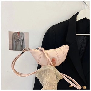 Detail view of pink quilted leather croissant bag with fine stitching and slim strap