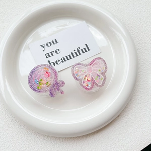 Detail view of sparkly glitter lollipop and bow phone grip stands with sequins