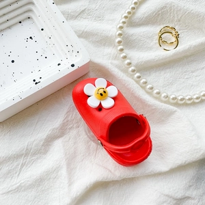 Close-up of a red slipper phone grip with a cute 3D sunflower charm on fabric