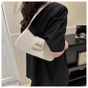 Details der eleganten cremefarbenen Baguette-Tasche mit minimalistischer Goldschnalle