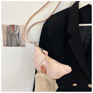 Detailed view of pink quilted croissant bag with pleated design and thin shoulder strap
