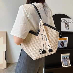 Large capacity straw tote bag with black leather trim and chic printed straps