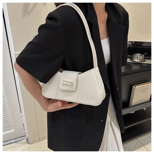 Detailansicht einer cremefarbenen Baguette-Tasche mit elegantem goldenem Verschluss