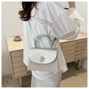 Modern straw crossbody bag featuring silver metallic flap and secure swivel lock detail