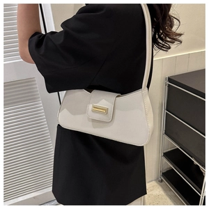 Detailansicht der cremeweißen Baguette-Tasche aus Leder mit goldener Schnalle
