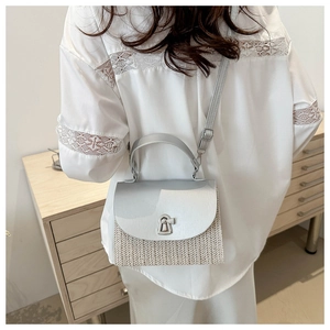 Detail showing metallic twist lock and woven texture of the silver grey handbag