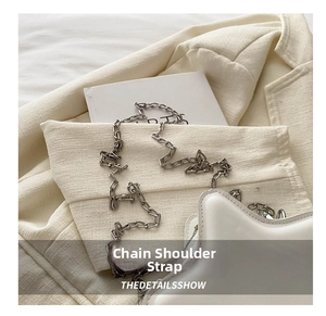 Close-up of a white star-shaped shoulder bag with a thick silver metal chain strap