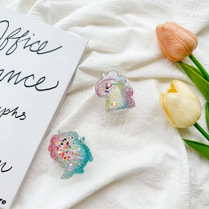 Detail of cute glitter dinosaur and unicorn phone grip with liquid sequins and stars