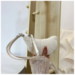 Macro detail of creamy white PU leather mini croissant bag with triple stitching accents
