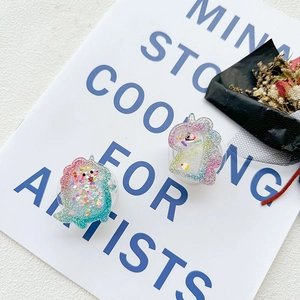 Macro shot of unicorn and dinosaur phone grips with colorful glitters and sequins