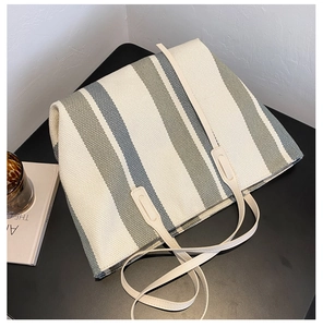 Detail of canvas tote bag showing thick striped fabric texture and cream shoulder straps