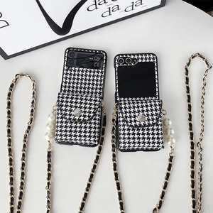 Samsung Galaxy Z Flip phone case with black and white houndstooth pattern and pearl strap
