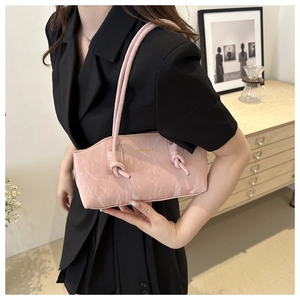 Détail du sac à bandoulière rose avec texture froissée unique et design de bandoulière nouée