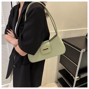 Chicke hellgrüne Baguette-Tasche mit Goldschnalle, getragen über schwarzem Blazer