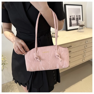 Vue détaillée du sac à main rose pâle avec texture plissée et bandoulière nouée