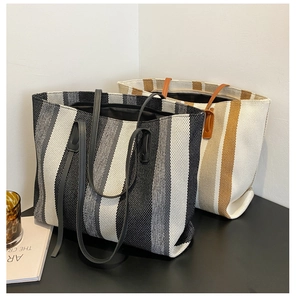 Detail of woven vertical stripe tote bags showing thick texture and dual shoulder straps