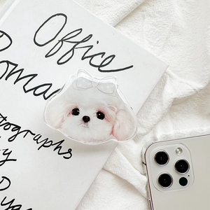 Detail of cute white puppy pop socket with bow on acrylic finish over a white phone