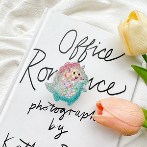 Detail of glitter dinosaur phone grip holder with colorful sequins and tulip decor