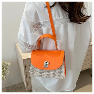 Detail of a chic straw-textured crossbody bag with orange leather flap and silver buckle