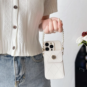 Detailed view of white quilted iPhone case with metal rose buckle and pearl chain handle