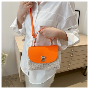 Detail of orange leather flap and beige woven texture on stylish crossbody bag