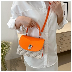 Detail of orange faux leather handle and woven straw texture with a silver metal clasp