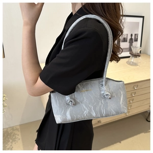 Détail du sac cabas argenté métallisé avec texture plissée et détail de bandoulière nouée