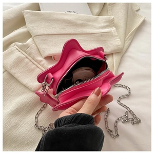 Detail view of the pink star-shaped bag interior with chain strap and daily essentials