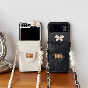 Detail of luxury quilted leather phone case with butterfly clasp and pearl chain strap