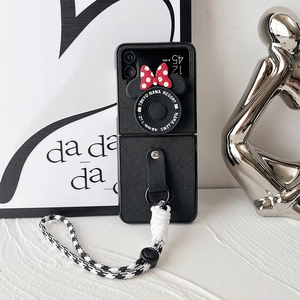 Detail of Galaxy Z Flip case with retro camera design, red bow, and checkered strap