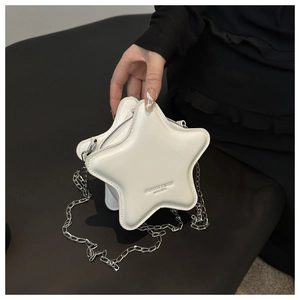 Macro detail of the star-shaped white leather bag with a silver chain shoulder strap