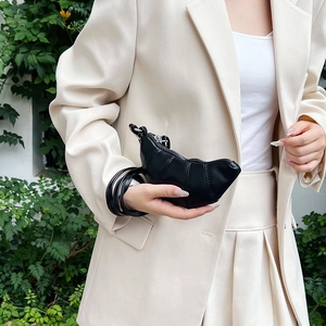 Minimalist black leather croissant shoulder bag with quilted details and thin strap